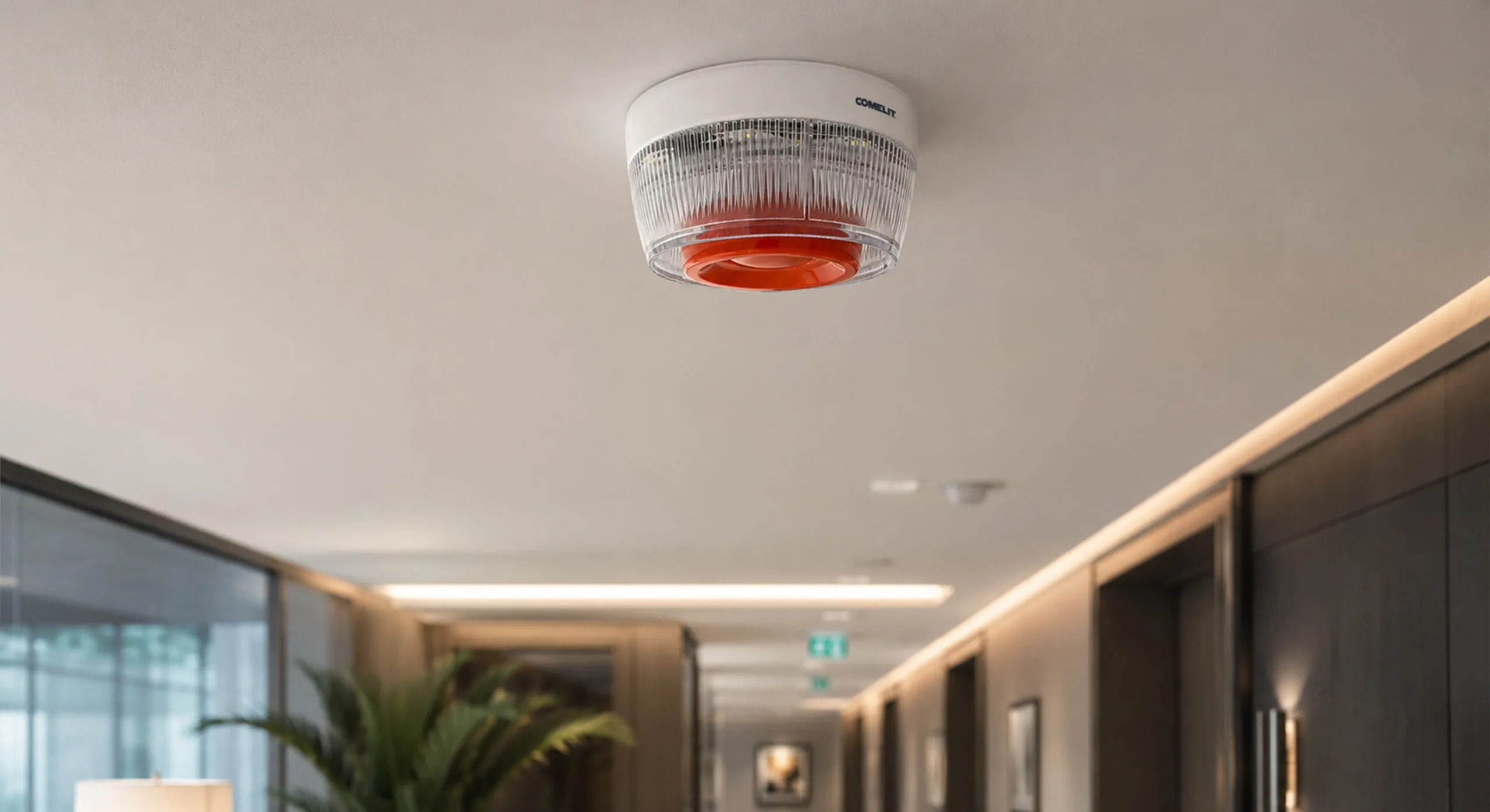 Segnalatore ottico-acustico Comelit installato a soffitto nel corridoio di un albergo per l'allarme antincendio