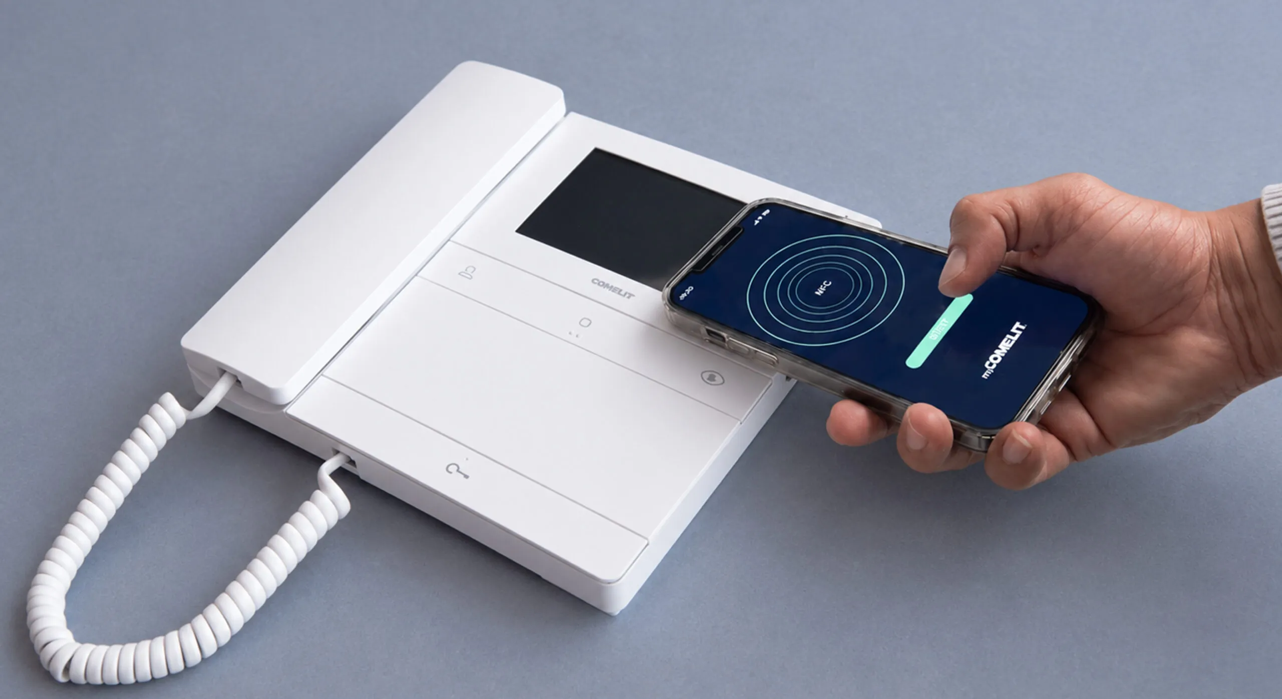 Tecnico avvicina lo smartphone con app myComelit al videocitofono Comelit per la configurazione tramite tecnologia NFC