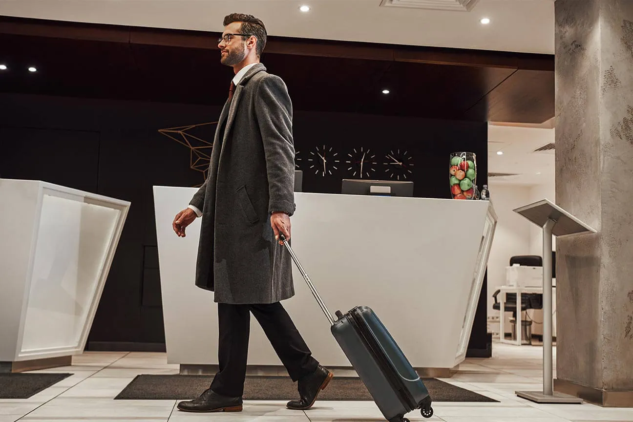 Cliente in arrivo presso un hotel moderno, simbolo della smart hospitality protetta da impianti di sicurezza Comelit pensati per il settore alberghiero.