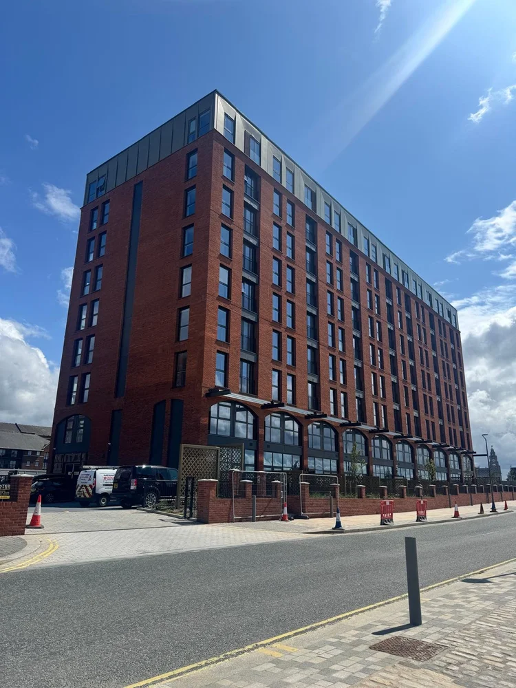 Foto dell'edificio Aquitania a West Waterloo Place, Liverpool, che mostra il prospetto in mattoni rossi e il tetto metallico.