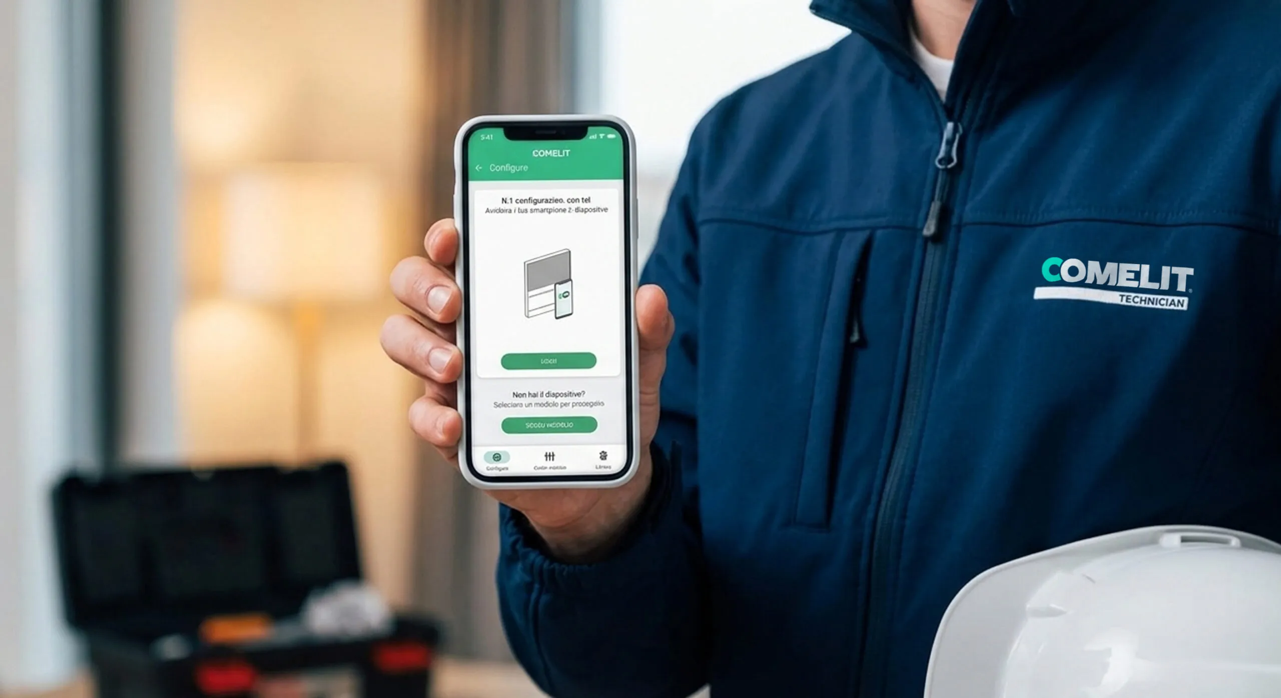 Installatore prepara la configurazione di un citofono Comelit dalla piattaforma MyComelit su laptop, con app mobile affiancata