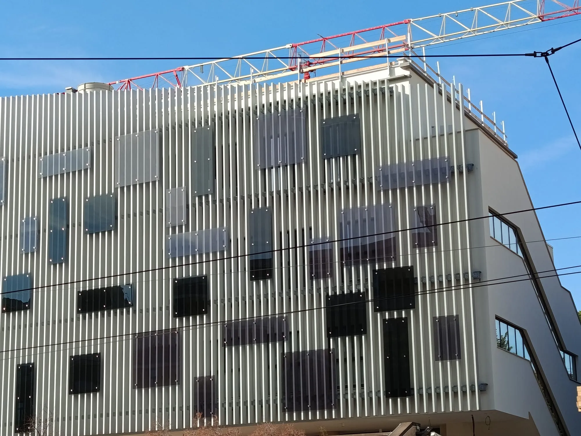 Facciata laterale del Palazzo dei Servizi Generali della Sapienza con frangisole in alluminio e cantiere in corso